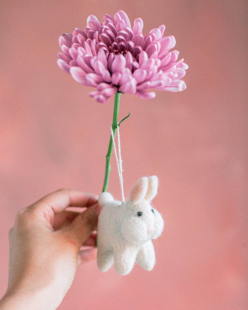 hand holding flower and white bunny ornament