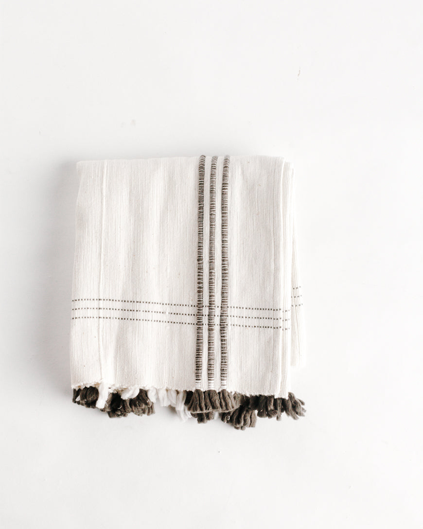 white and grey cotton table runner with tassels