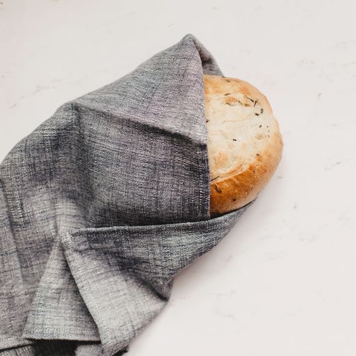 grey cotton dinner napkin around loaf of bread